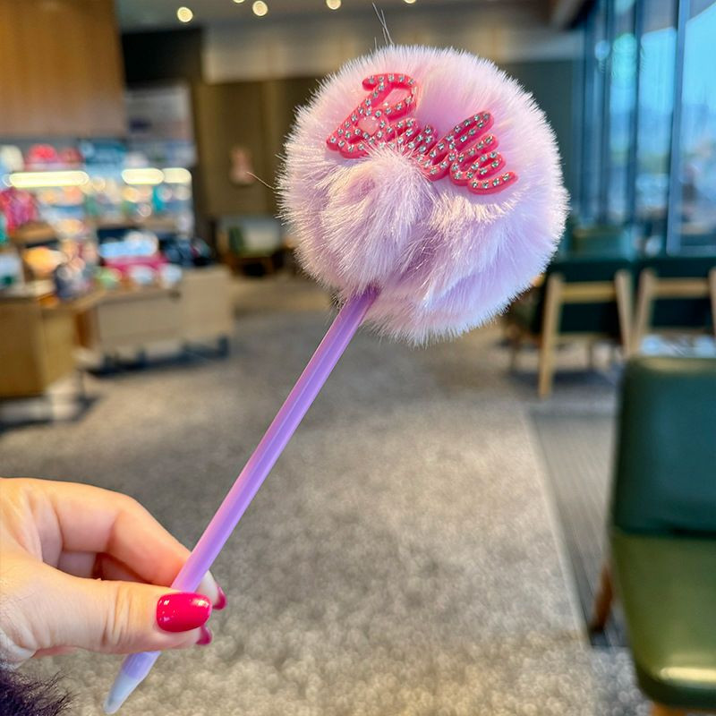 Stylos à pompon en peluche Barbie se distinguent par leurs boules duveteuses aux couleurs pastel et éclatantes, surmontées de l'inscription « Barbie » en strass scintillants.