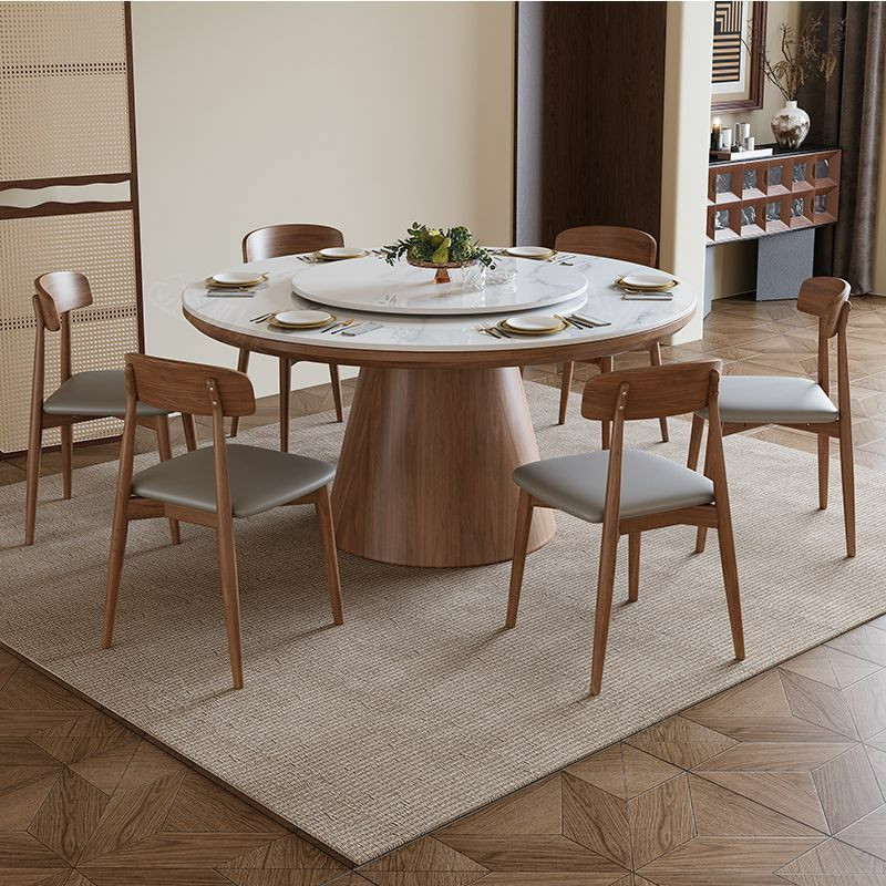 Table à manger ronde moderne en bois avec un plateau en pierre frittée et un plateau tournant central (type Lazy Susan), accompagnée de six chaises assorties au dossier incurvé et à l'assise grise.