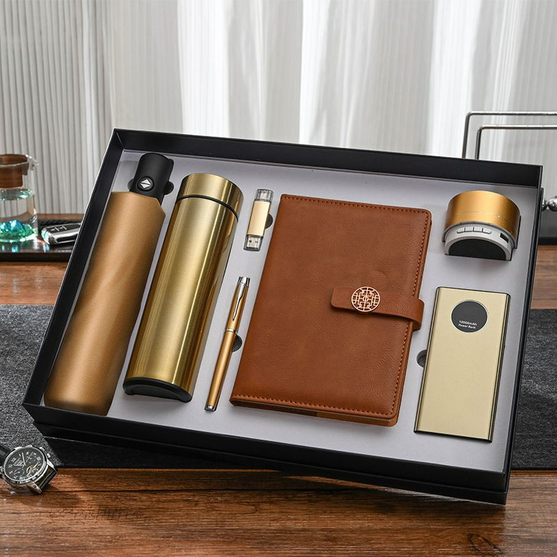 Coffret cadeau d'entreprise personnalisé 7-en-1. Il comprend une banque d'alimentation de 10 000 mAh avec affichage numérique, un thermos, un carnet de notes et un parapluie.