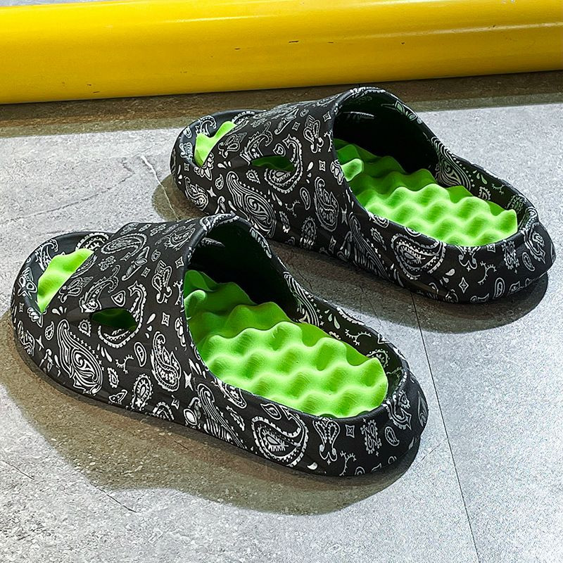 Claquettes de style « nuage » présentent un imprimé paisley noir et blanc avec une semelle intérieure verte ou orange contrastante.